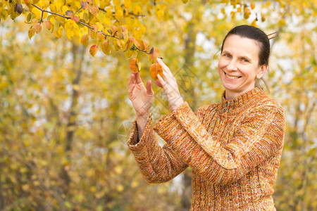 季节秋天一个笑着的成年caucasians女人在采摘橙苹果叶喜悦公园图片