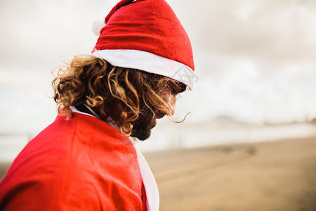 肖像女士年轻金发男在海滩上打扮成圣诞老人红色的图片