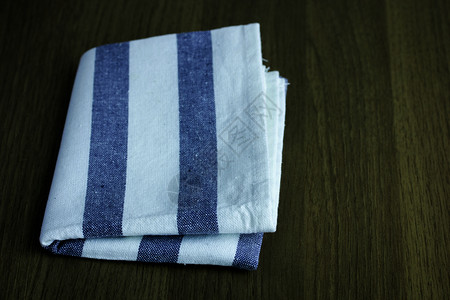 帆布木制桌上折叠的餐巾纸桌布蓝色的图片