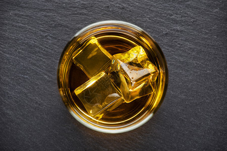 寒冷的玻璃立方体圆杯威士忌和冰在黑色背景从上方的黑底照圆杯威士忌和黑底面的冰背景图片