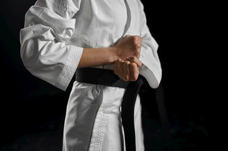 运动员制服白人和的男空手道斗士有黑带战斗姿势黑暗背景的Karateka运动武术在比赛前训练在黑人和服的白色同衣斗士中有黑带战斗机图片