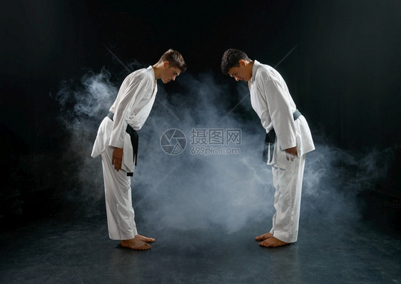 白和服中的两只男空手道战斗黑暗背景的拳手关于锻炼武术打架比赛两只男空手道在白和服中战斗oopicapi白色的肌肉发达图片