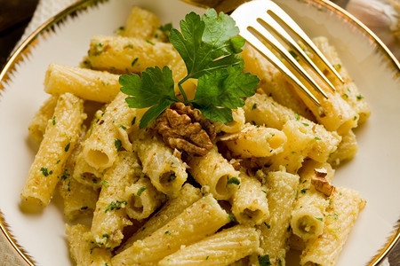香蒜区域意大利地盘子由意大利面条和木制桌上的胡桃虫粉制成图片