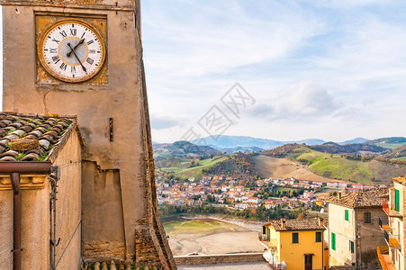 落下爬坡道意大利语Sassocorvaro时钟塔的景象小城镇Mercatare和山丘背景图片
