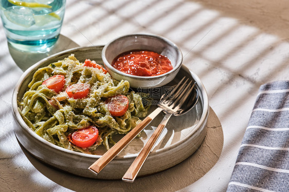 土制塔利亚泰尔意大面带有西红柿和鳕鱼地中海营养食物图片