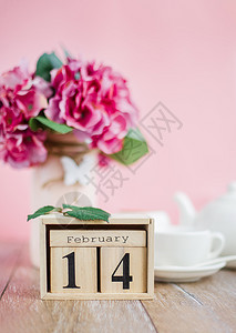 2月14日的华伦人节快乐木质日历2月14日有花朵与白杯爱的概念复制空间华伦人节快乐树皮日Wooden日历2月14日有花朵与白杯希图片