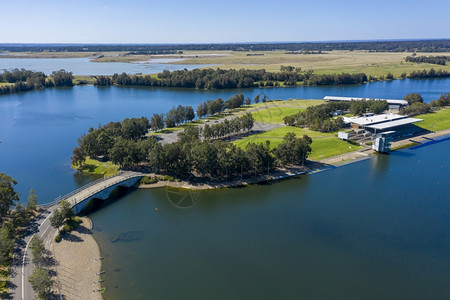 划独木舟在澳大利亚区域绿农田环绕的划船中心对蓝色水进行空中观测以察澳大利亚区域绿农田周围的蓝水一种湖图片