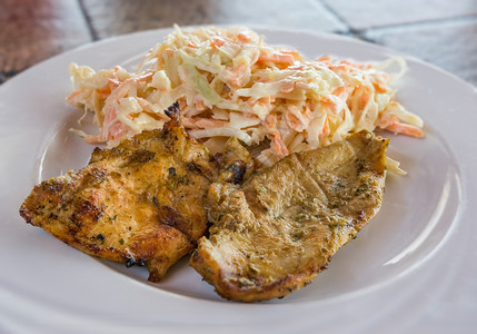乳房由胡萝卜酸菜和蛋黄酱制成的沙拉加烤鸡肉在白盘上卖晚餐鱼片图片