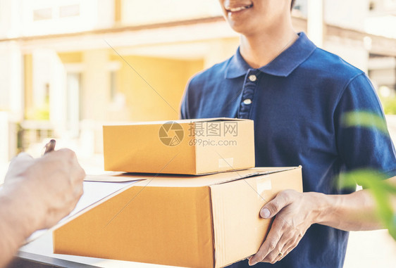 用户在剪贴板上签名以便从在家的专业送货员那里接收包裹邮差目的地件图片