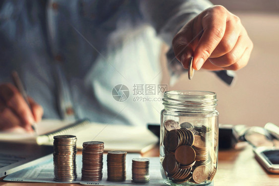 节省债务成人储蓄钱用手把硬币放在玻璃杯中金融概念图片