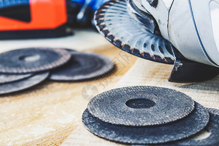 手角磨机的圆在床附近木板上角磨机的工具和维修作圈的概念在磨床附近的木板上制黑色图片