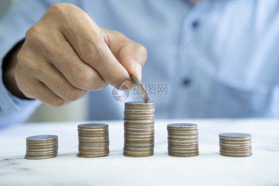 商人节约钱的概念手拿硬币装在玻璃瓶里支付保持退休图片