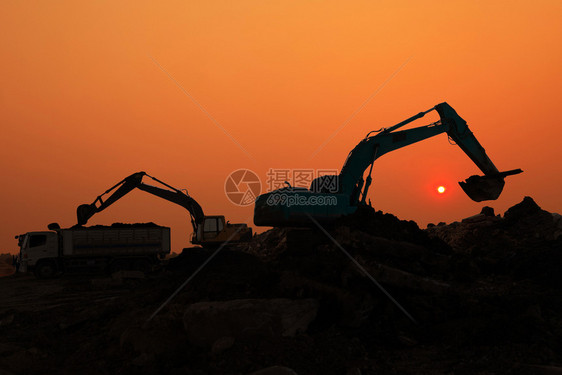 活动土壤日落天空下建筑工地挖土机装载器的轮光铲图片