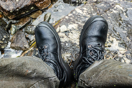 河边的黑山靴子为旅游者穿脚鞋徒步登山提供防水靴子皮革的人们图片