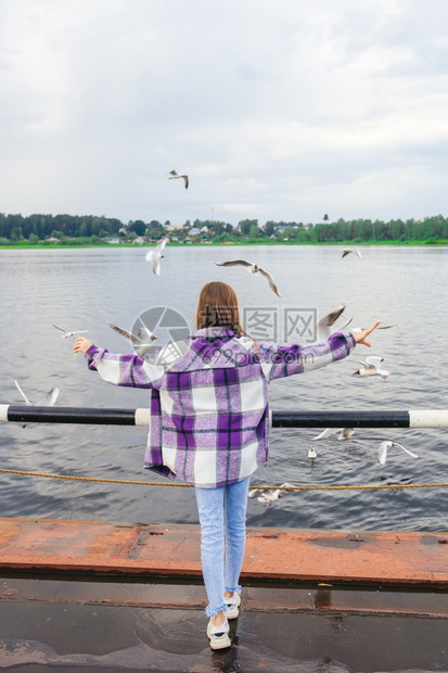 小女孩的后视镜喂海鸥在Cute河上喂养海鸥小可爱的姑娘喂养海鸥湖活力黎明图片