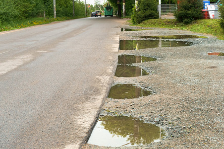 雨后的路柏油边缘的水坑柏油路边缘的水坑雨后路人行道土地旅图片