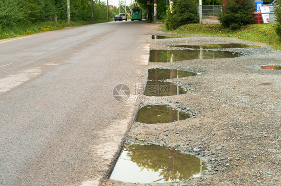 雨后的路柏油边缘的水坑柏油路边缘的水坑雨后路人行道土地旅图片