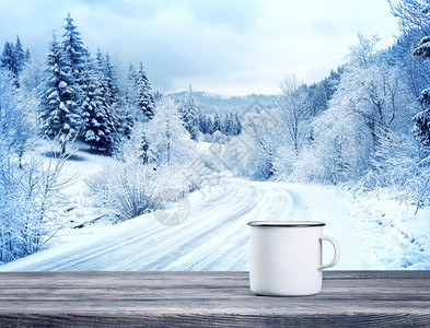 白色杯子在冬季风景背的木制桌子上饮酒白杯自然一月雾凇图片