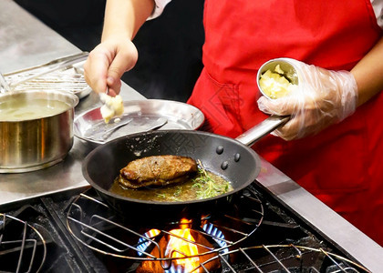 厨师在房炉灶的煎锅中用火焰做饭气体精加工一顿饭图片