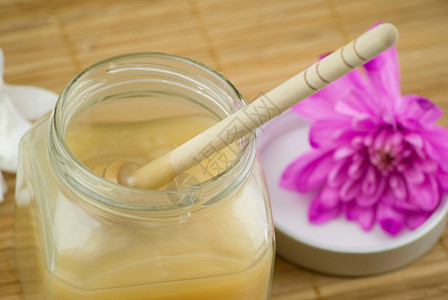 关心身体花松软的杏仁椰子香草奶和木垫上的蜂蜜浴泡沫芳香图片