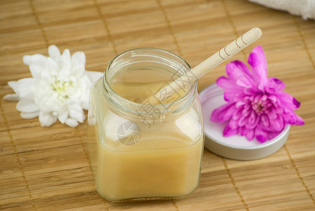 松软的杏仁椰子香草奶和木垫上的蜂蜜浴泡沫芳香毛巾治疗美丽图片