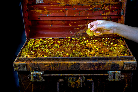 大量堆叠的金币在女士手中宝箱在黑色背景未来交换宝藏图片