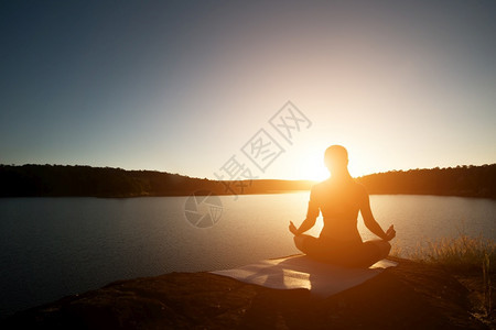 女士健康休光月在日落时山湖做瑜伽徒步旅行者美丽的图片