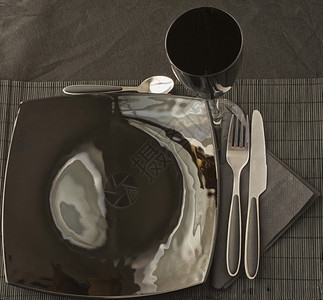 超过闪亮的黑色优雅餐盘和黑垫上具锋利图片