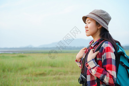 一种放松愉快亚裔女在山上和天空背景闭眼睛享受大自然一个年轻女孩正在渡暑假旅行一个年轻女孩正在旅游图片