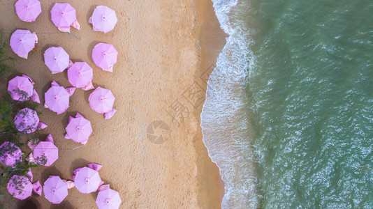 粉红雨伞沙滩椅和沙滩海浪图片