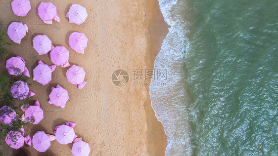 粉红雨伞沙滩椅和沙滩海浪图片