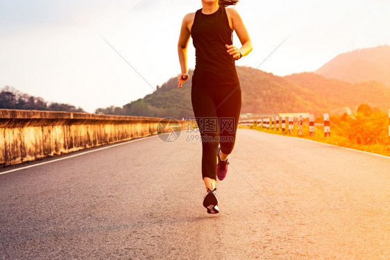 积极的女运动员在一条健康道路上奔跑的妇女运动步年轻的图片