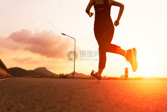 女孩运动员在一条健康道路上奔跑的妇女运动成人图片