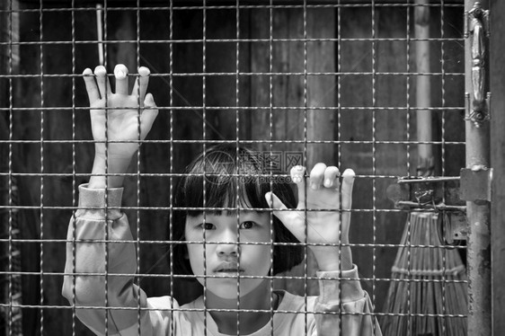 围栅后面的女童手握钢网膜黑白相片人类链在后面图片