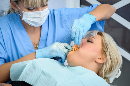 女牙医给病人牙齿做手术图片