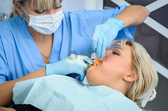 女牙医给病人牙齿做手术图片