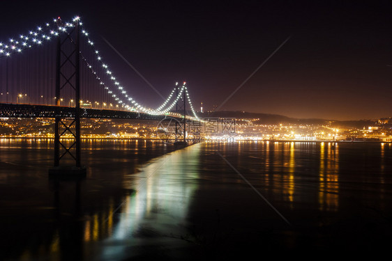 架桥和河流夜照有灯光和反葡萄牙城市的场景图片