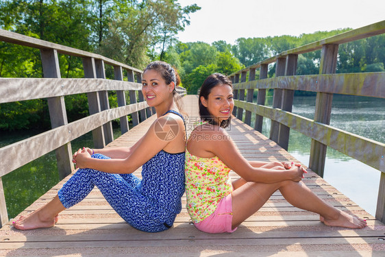 自然两名青年妇女坐在水上木桥一起幸福印度人图片