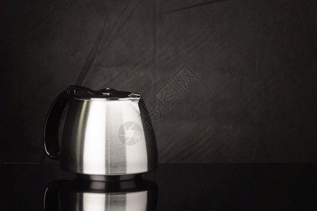 配饰不锈钢咖啡壶黑色镜面上盖有塑料的胶罩空间复制咖啡壶黑色面纱隔离在镜面上复制空间国内的作者图片