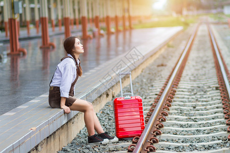 旅游亚洲孕妇在火车站等待的亚洲孕妇旅行者携带她的车厢红包贝利女孩爱保持图片