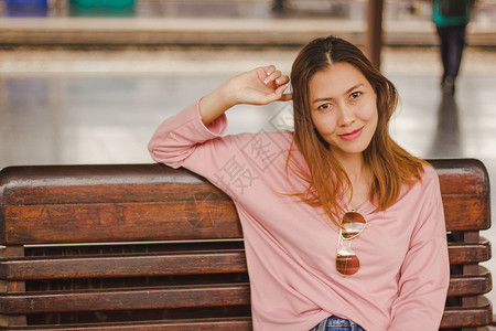 女孩相机旅行坐在火车站椅子上的妇女图片