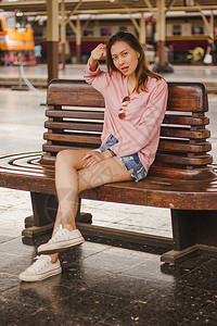 白色的背包泰国坐在火车站椅子上的妇女图片