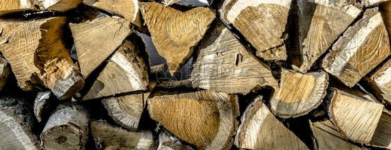 环境分裂在冬季壁炉火灾背景或壁纸的一堆切碎木柴近距离观察树干图片