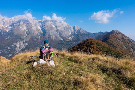步行在山顶的秋天人类登山者坐着看地风景纳达林背包背景图片