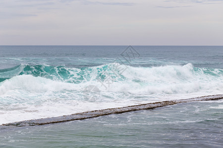冲浪美丽的海洋岸带泡沫风力的移动波浪绿石水云图片