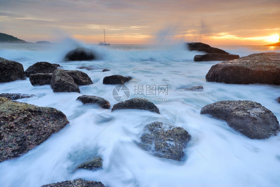 地平线丰富多彩的海浪冲击直线撞海滩上的岩石蓝色图片