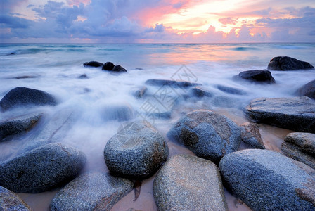 夏天结石海浪冲击直线撞海滩上的岩石紫色图片