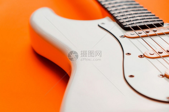艺术垂直的音乐会橙色背景的白电吉他详细信息图片