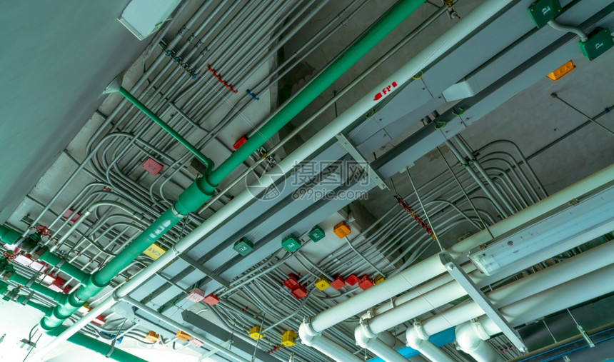 电气安装在聚氯乙烯排水系统塑料管道和工业建筑天花板造上清洁水的电路管道系统和动钢管缆安装在聚氯乙烯上限排水系统塑料管道上工业的红图片
