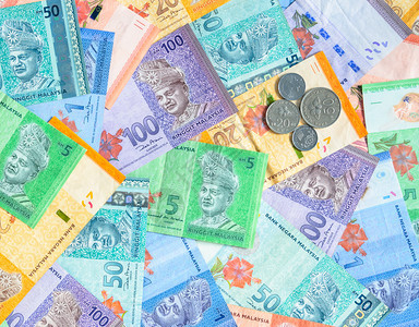 金属外国的马来西亚林吉特纸币和硬背景的马来西亚货币五十二和的森硬币在一五二十和百林吉特纸币的上橙图片
